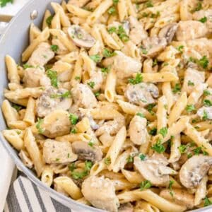 Creamy penne pasta with chicken and mushrooms, topped with parsley.