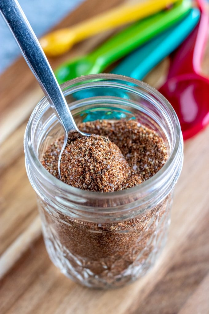 taco seasoning in a glass jar with a spoon