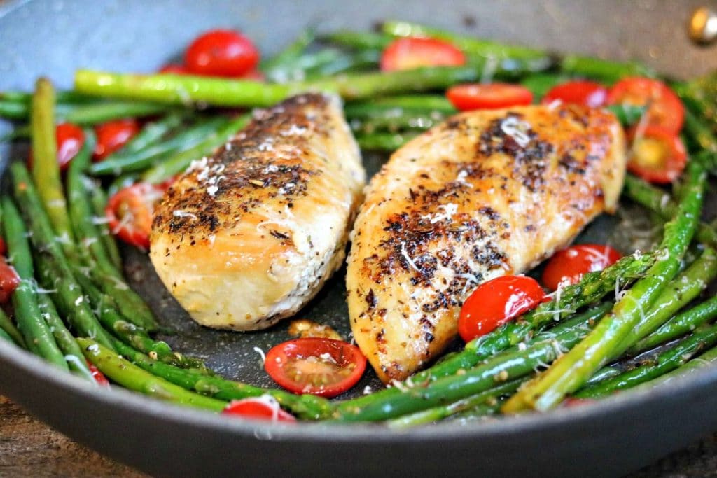 chicken with green beans and tomatoes in a skillet