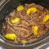 Shredded beef with yellow peppers in a slow cooker.