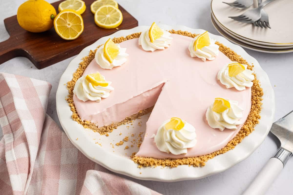 A close-up of the creamy pink lemonade pie cut upon with a slice missing.