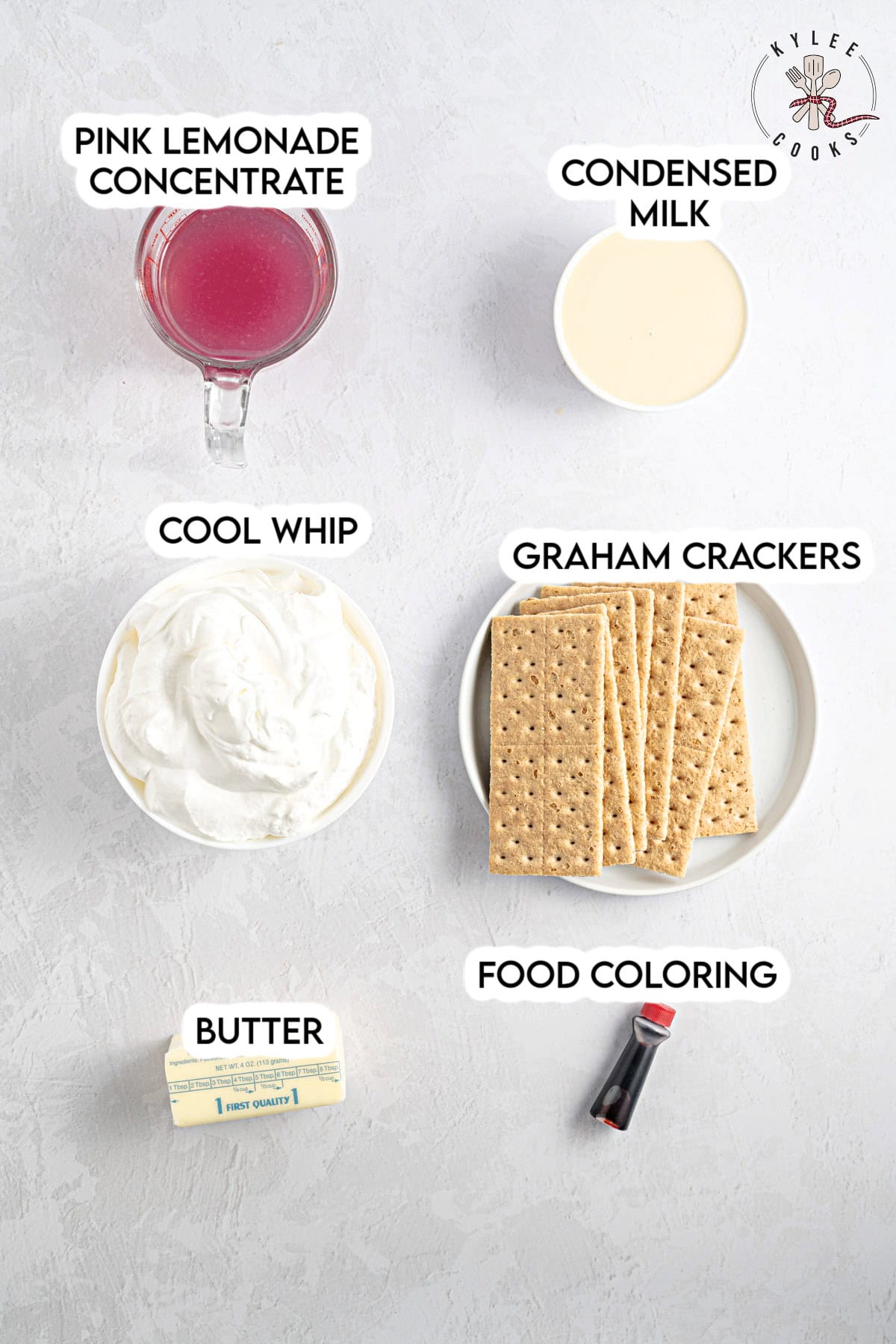 Ingredients for pink lemonade pie: pink lemonade concentrate, condensed milk, Cool Whip, graham crackers, food coloring, and a stick of butter, all labeled.