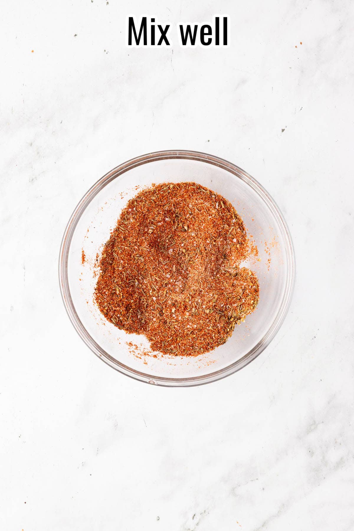 Seasoning mix fully combined in a glass bowl. Text on the image says 'Mix well'.