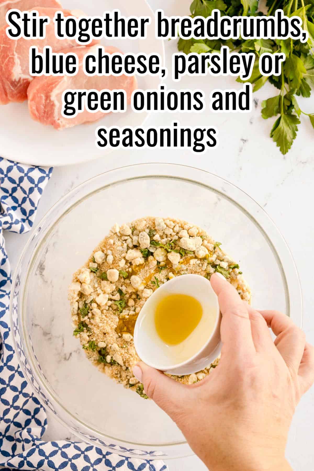 A hand pouring olive oil into a bowl of breadcrumbs, blue cheese, and parsley. Text on the image says 'Stir together breadcrumbs, blue cheese, parsley or green onions and seasonings'.