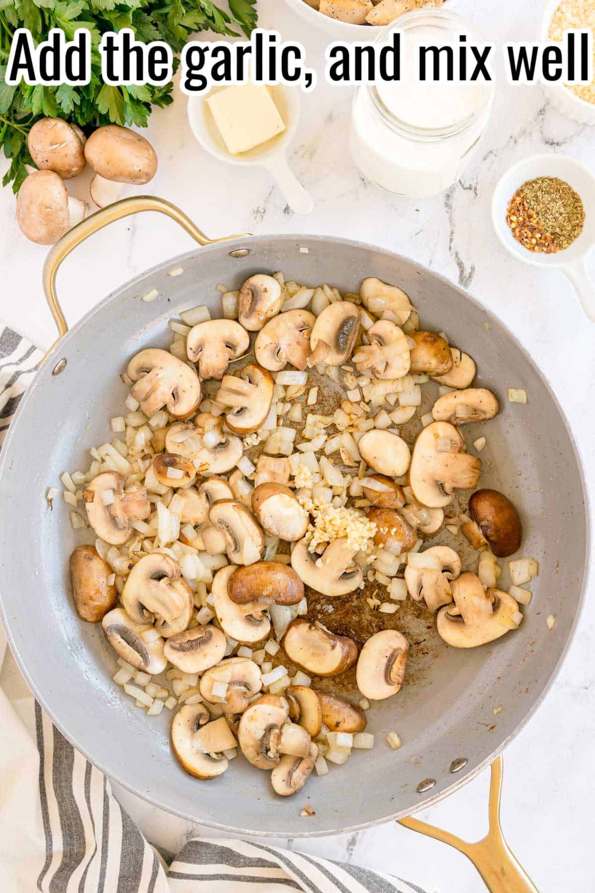 Mushrooms, onions, and garlic cooking in a skillet. Text on the image says 'Add the garlic, and mix well'.