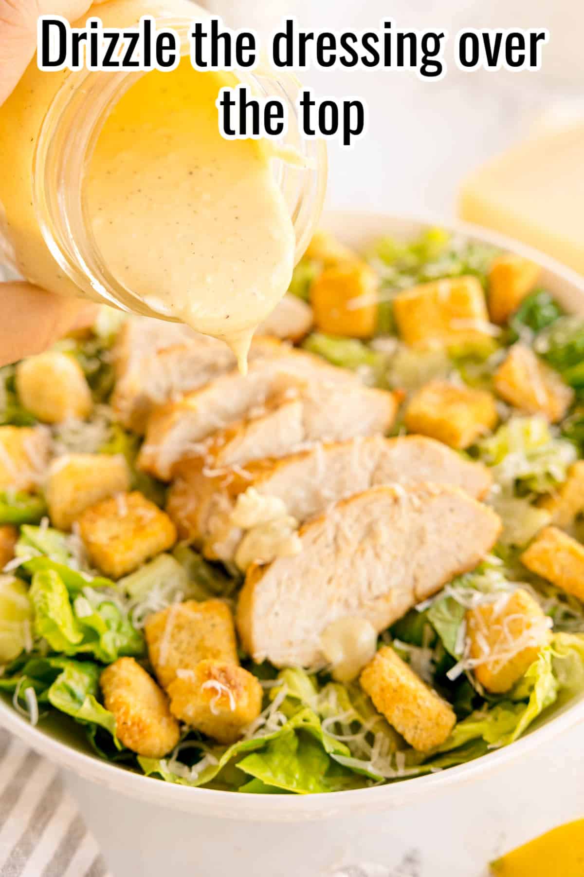 Dressing being drizzled over chicken Caesar salad from a jar. Text on the image says 'Drizzle the dressing over the top'.