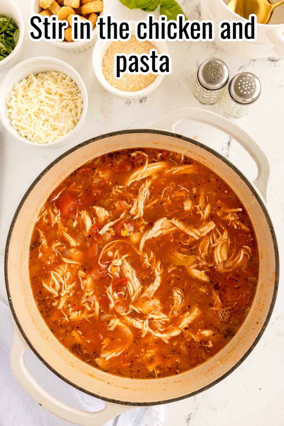 Shredded chicken and pasta stirred into the tomato broth. Text on the image says 'Stir in the chicken and pasta'.