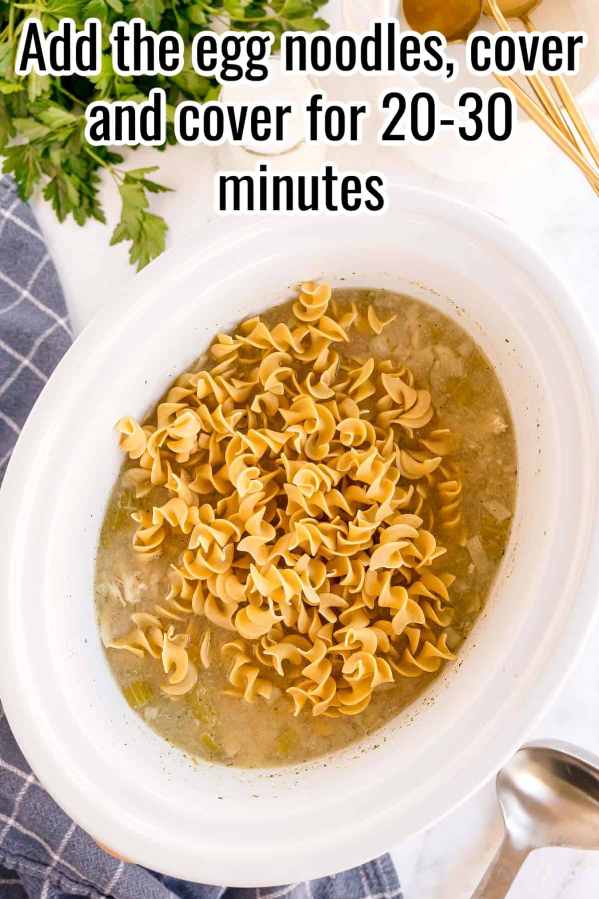 Egg noodles added to the slow cooker with broth. Text on the image says 'Add the egg noodles, cover and cover for 20-30 minutes'.