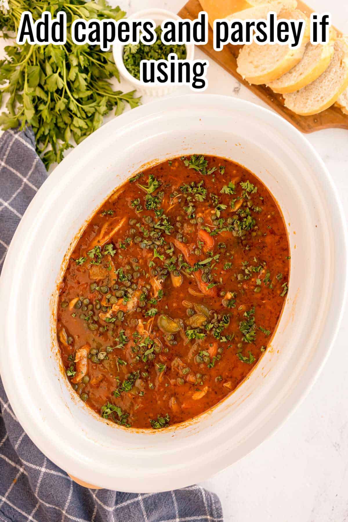 The finished crockpot chicken cacciatore, garnished with capers and fresh parsley, with a text overlay that reads "Add capers and parsley if using."
