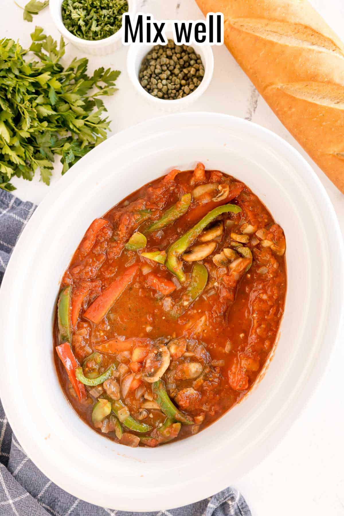 A crockpot filled with mixed chicken, vegetables, and sauce, ready to cook, with a text overlay that reads "Mix well."