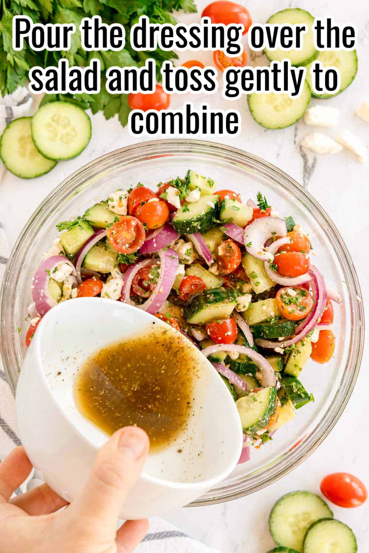 Dressing being poured into a bowl of chopped cucumber salad. Text on the image says 'Pour the dressing over the salad and toss gently to combine'.