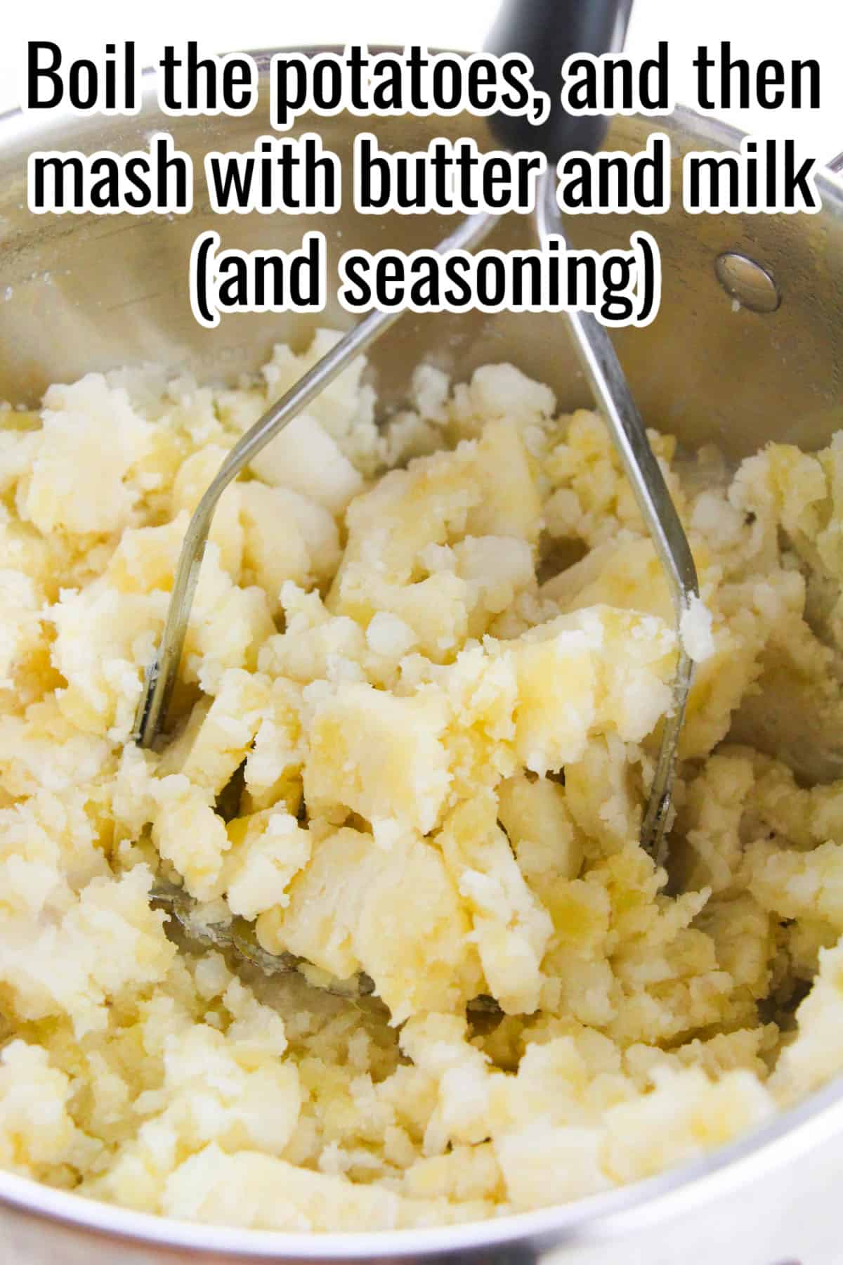 A pot of chopped potatoes being mashed with a hand masher. Text on the image says 'Boil the potatoes, and then mash with butter and milk (and seasoning)'.
