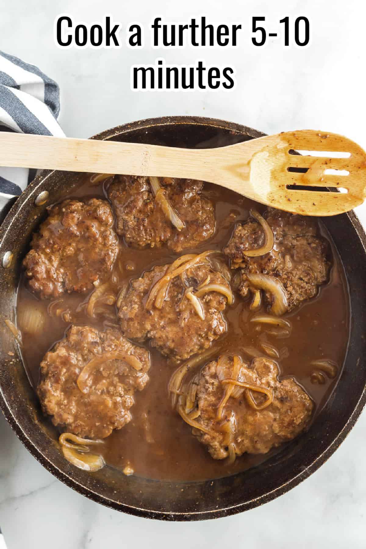 Hamburger steaks simmering in thick onion gravy in a skillet, with text overlay reading "Cook a further 5-10 minutes."