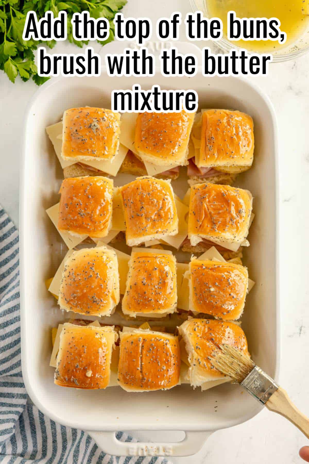 Add the top of the ham and cheese sliders buns brush with the butter mixture.