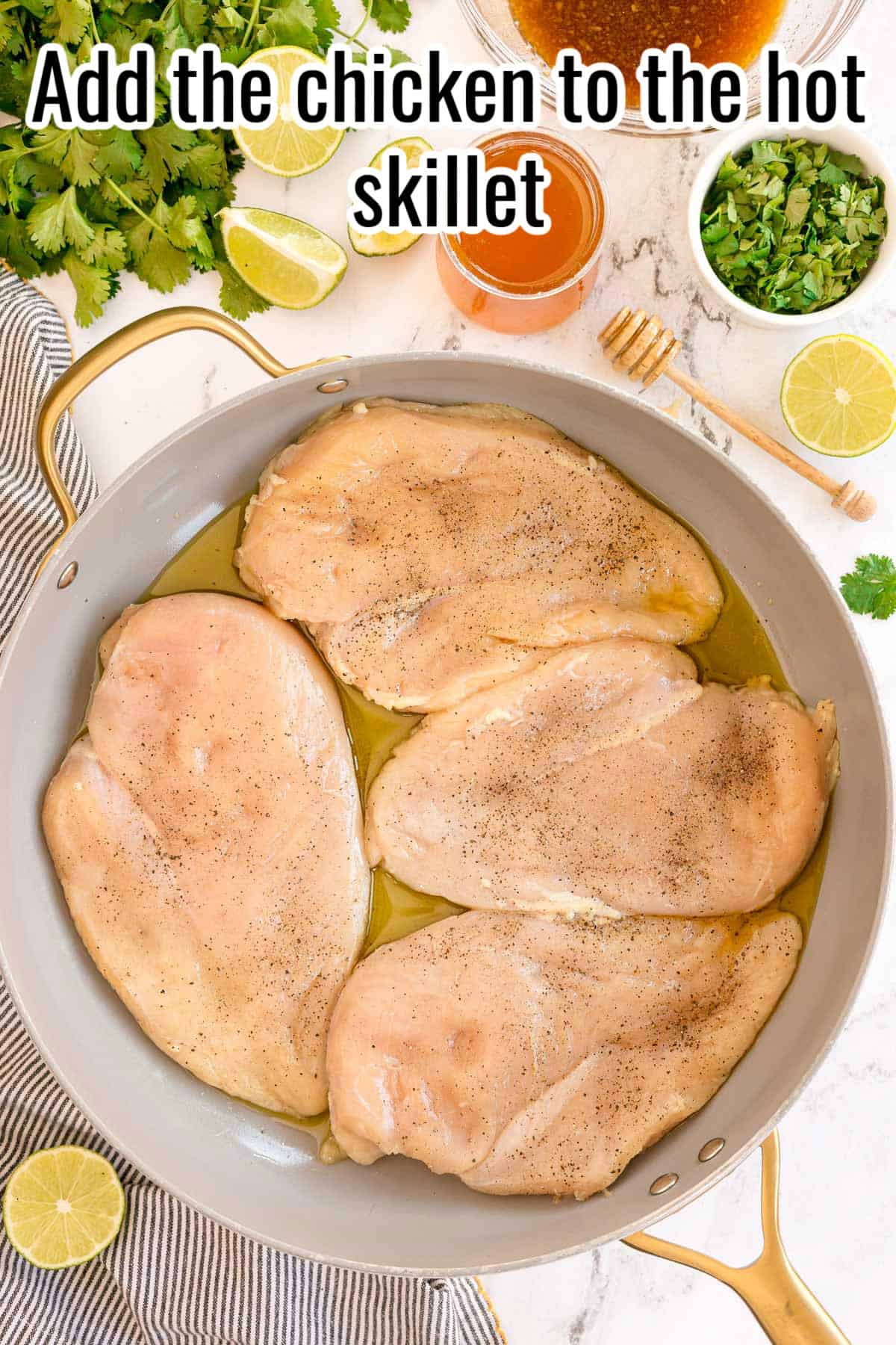 Raw chicken breasts in a skillet with oil. Text on the image says 'Add the chicken to the hot skillet'.