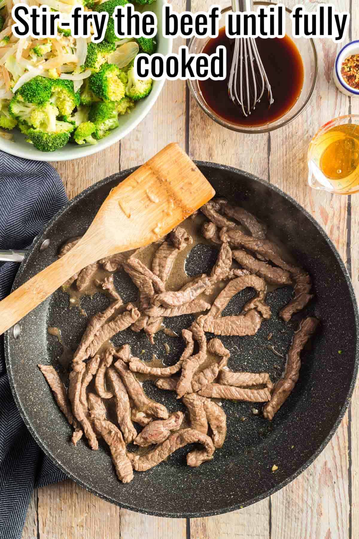 A skillet with beef stir-fried until fully cooked, with a wooden spatula stirring. Text on the image says 'Stir-fry the beef until fully cooked'.