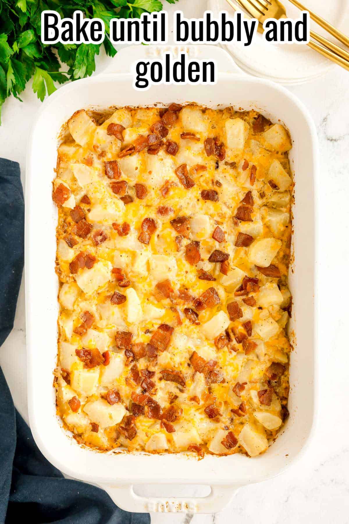 A golden baked casserole with potatoes and bacon in a white dish. Text on the image says 'Bake until bubbly and golden'.