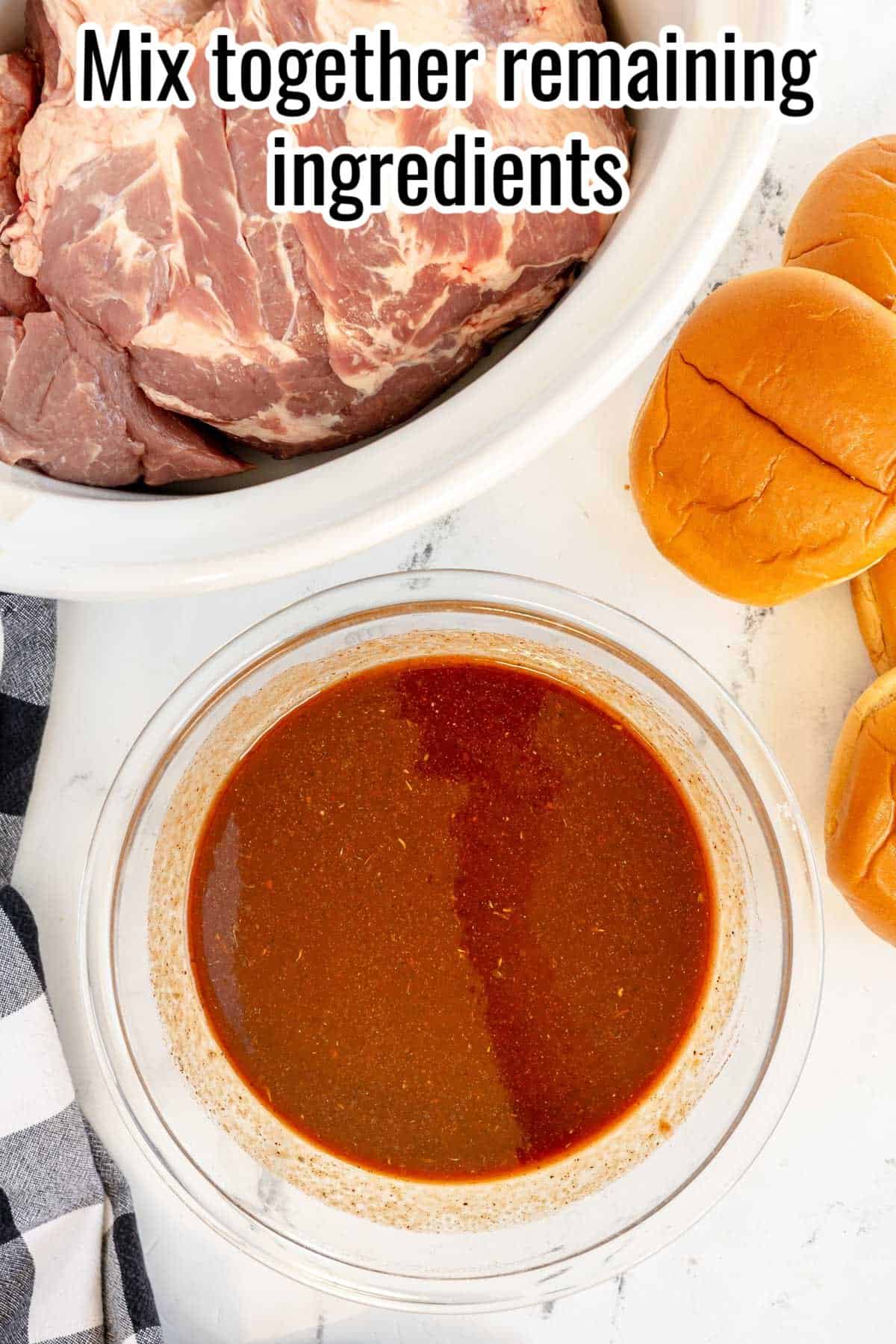 A bowl of sauce, a few raw beef cuts in a white slow cooker, and three burger buns are positioned on a white countertop. The caption reads "Mix together remaining ingredients.