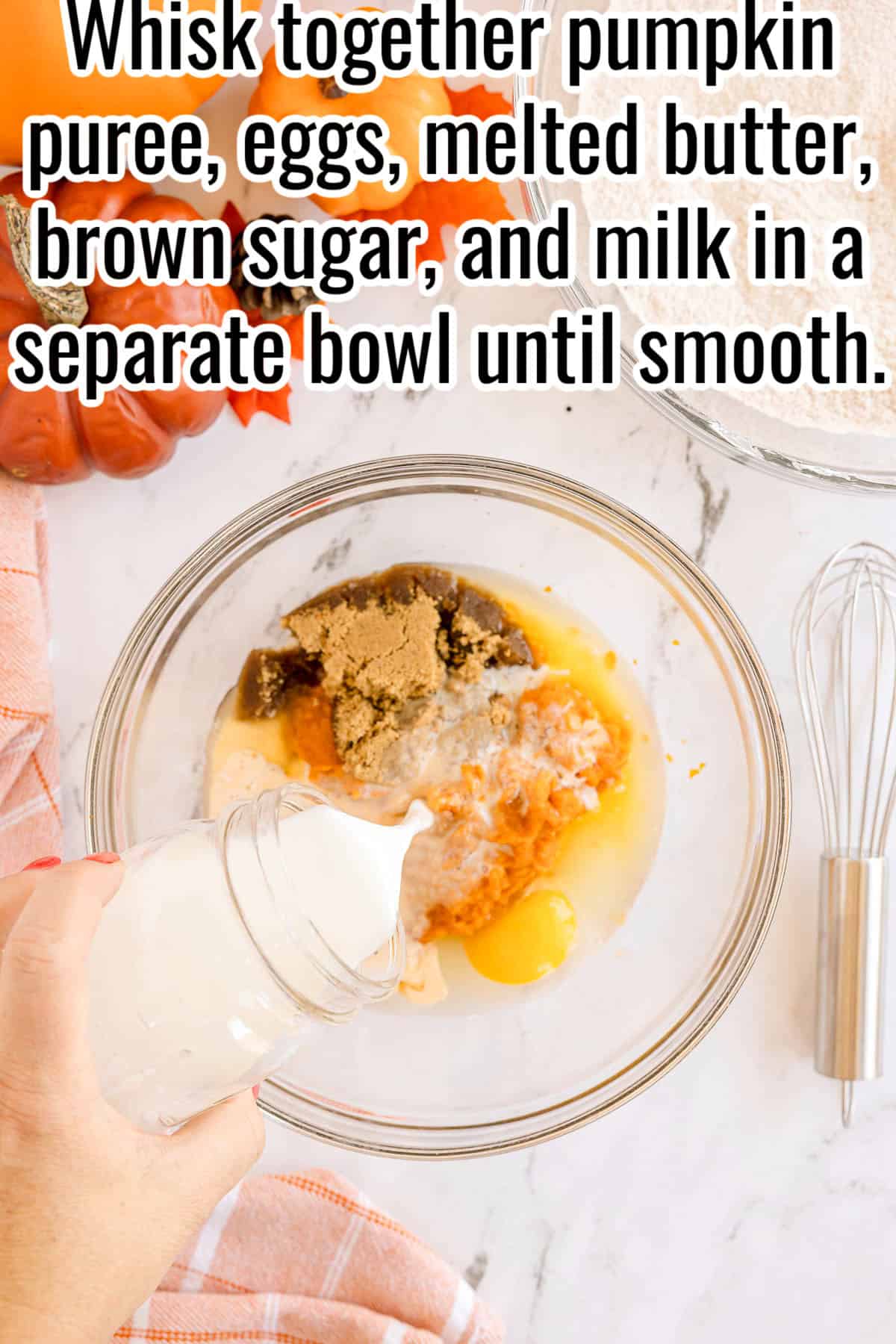 A hand pouring milk into a bowl with pumpkin puree, eggs, brown sugar, and melted butter. Text on the image says 'Whisk together pumpkin puree, eggs, melted butter, brown sugar, and milk in a separate bowl until smooth.'