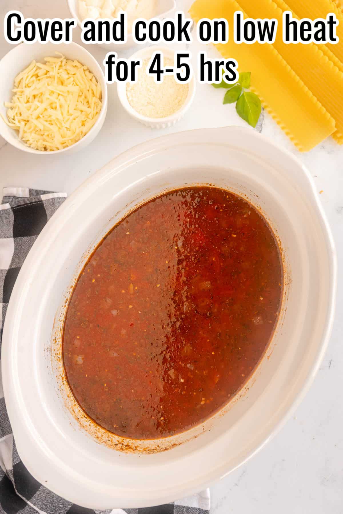 A slow cooker with cooked lasagna soup base.
