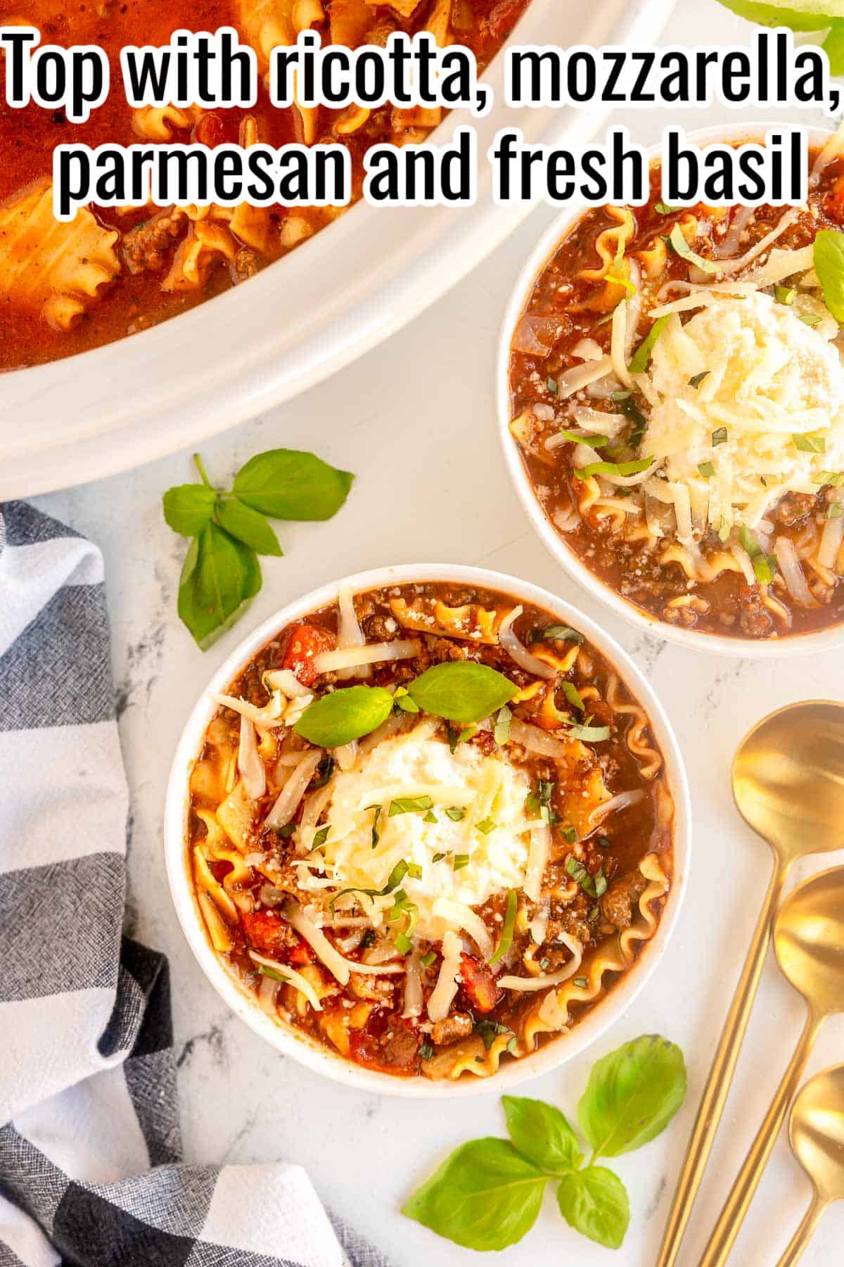 two bowls of lasagna soup with a checkered napkin and spoons.