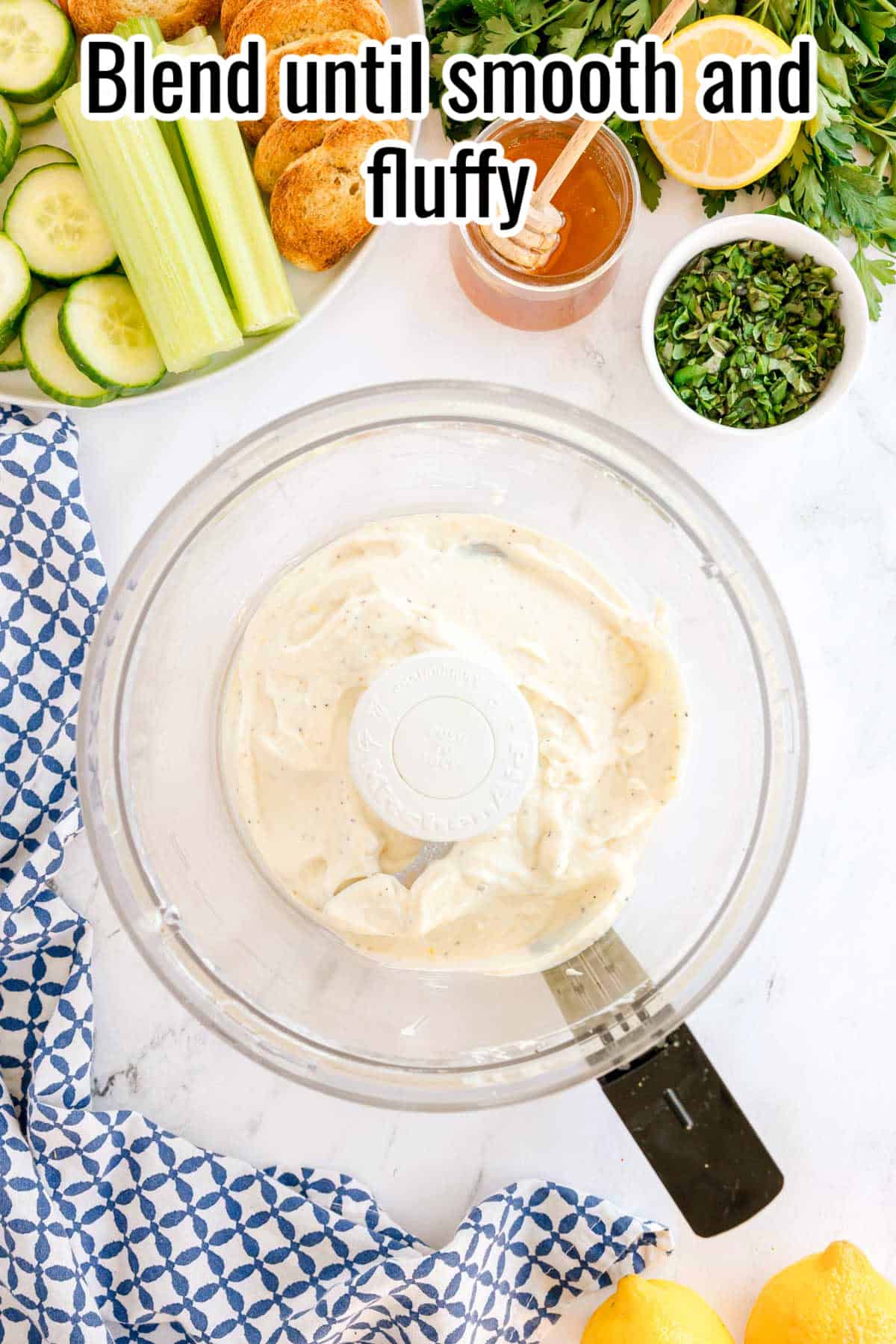 Blended whipped ricotta mixture in a food processor bowl. Text on the image says 'Blend until smooth and fluffy'.