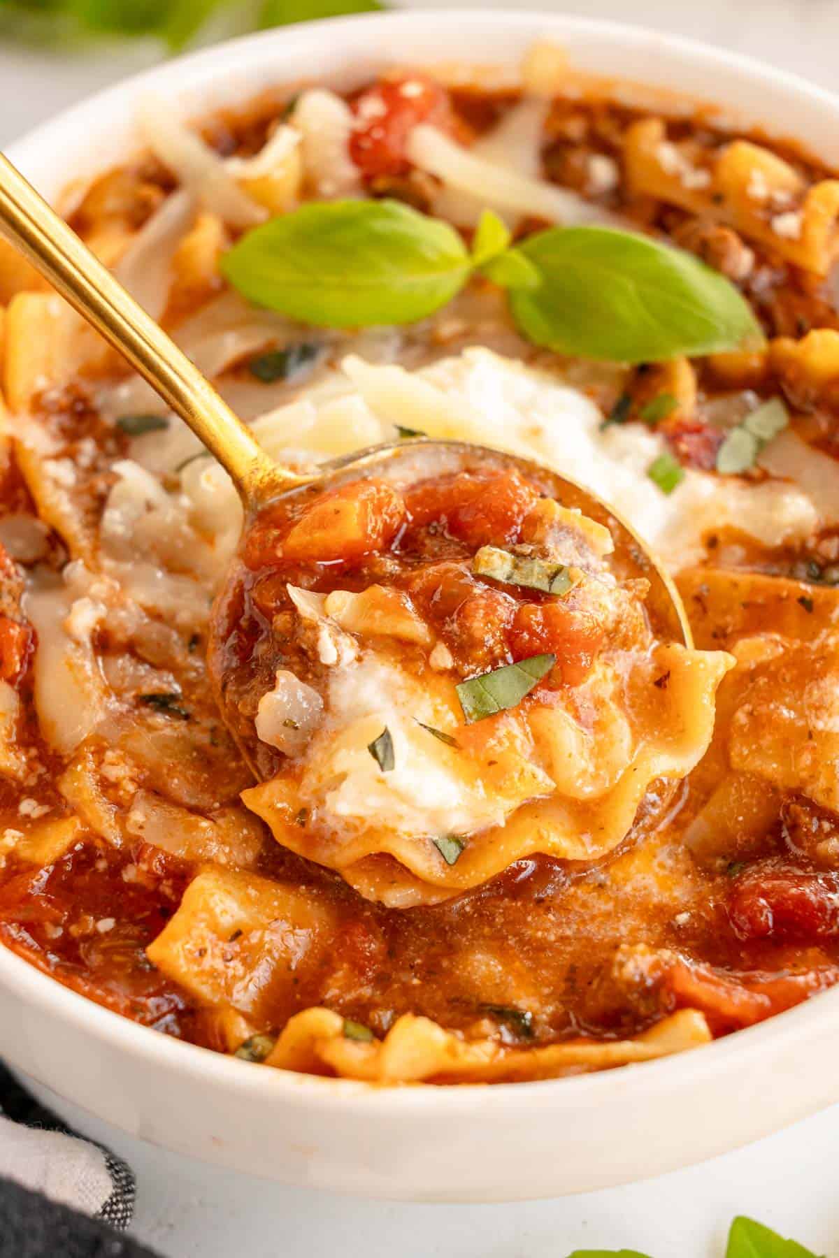 Slow cooker lasagna soup in a bowl with a spoon.